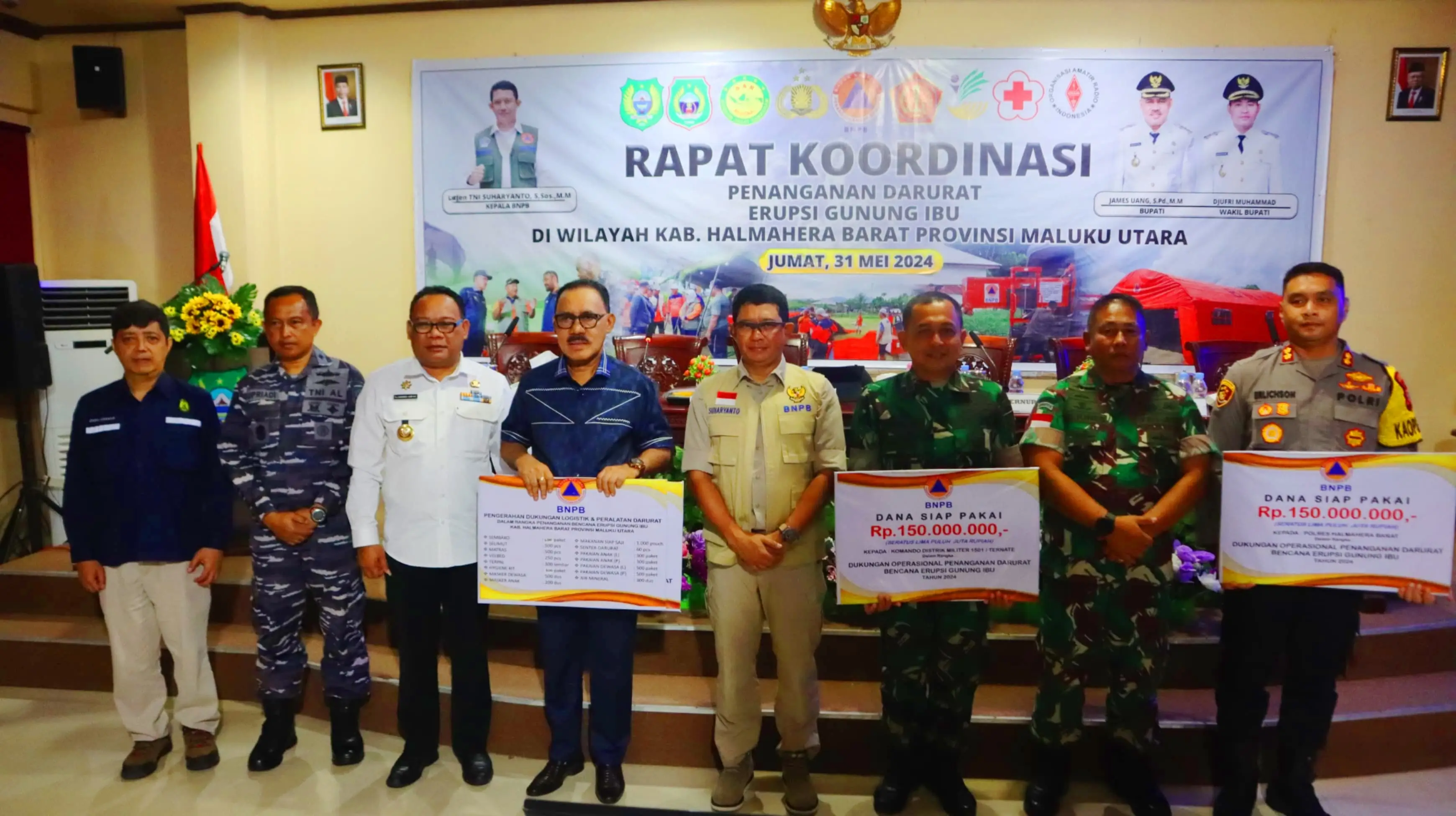 Kepala BNPB Letjen TNI Suharyanto, S. Sos., M.M (menggunakan rompi) saat memberikan simbolis dukungan bantuan operasional darurat tahap dua kepada Pemerintah Kabupaten Halmahera Barat, Kodim 1501 / Ternate dan Polres Halmahera Barat setelah Rapat Koordinasi Penanganan Darurat Bencana Erupsi Gunungapi Ibu di Kantor Bupati Halmahera Barat, Maluku Utara pada Jumat (31/5).